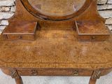 a small wooden vanity with a mirror on top of it