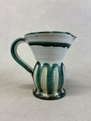 une tasse à café verte et blanche posée sur une table