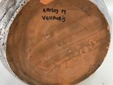 an image of a person is holding a vase with a tag on it