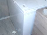 a white toilet sitting in a bathroom next to a wooden cabinet