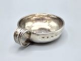 a silver bowl with a spoon in it sitting on a table