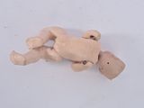 a small wooden doll laying on the floor with a skateboard