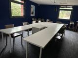 des tables et des chaises dans une pièce aux murs et aux fenêtres bleus