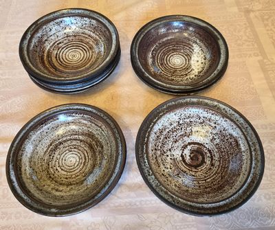 quatre assiettes marron et blanches posées sur une table