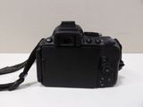 a black camera on a white table with a black strap