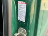 a close up of a door handle on a green vehicle