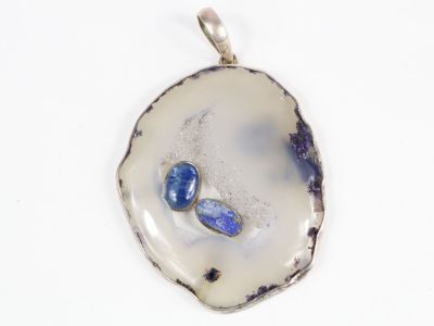pendentif plaqué argent orné de pierres bleues sur fond blanc