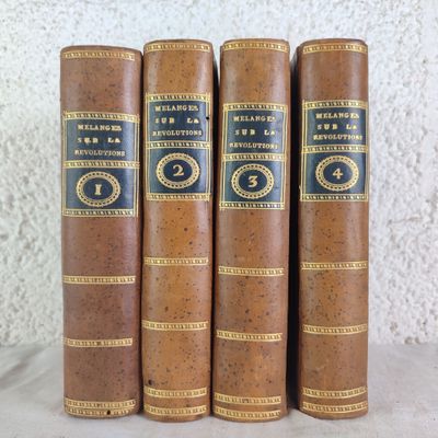 three old books sitting on top of a table next to each other