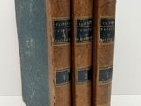 three old books sitting on top of each other on a table