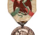 une vieille médaille sur laquelle figurent un homme et un aigle