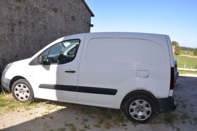 a white van parked in front of a brick building