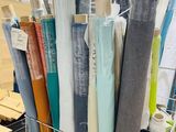many rolls of fabric in a shopping cart in a store
