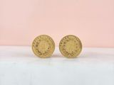 a pair of gold coins sitting on top of a table