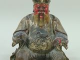 une image représentant la statue d'un homme barbu portant un chapeau
