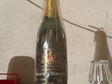 a bottle of champagne sitting on a shelf next to a bottle of wine