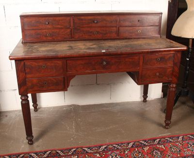 a wooden desk with drawers and a lamp next to it
