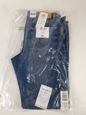 two pairs of blue jeans are wrapped in plastic on a white surface