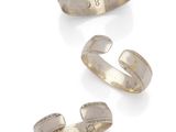 three silver cuff rings on a white background
