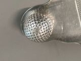 a close up of a metal strainer on a table