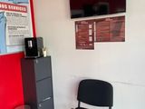 une chaise noire posée devant un mur rouge
