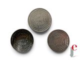 three different types of coins sitting on top of a white surface