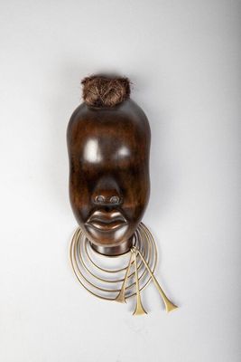 une image d'un masque en bois accroché au mur