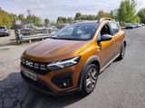 La voiture orange est garée sur le bord de la route.