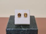 a close up of a pair of earrings sitting on top of a marble block