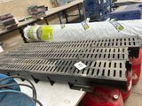 une grille métallique posée au sol, à côté d'une borne d'incendie rouge