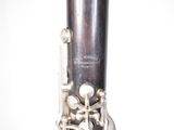 a close up of a silver clarinet with a white background