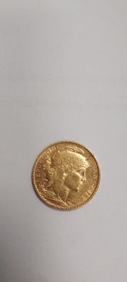 gros plan d'une pièce d'or sur une surface blanche