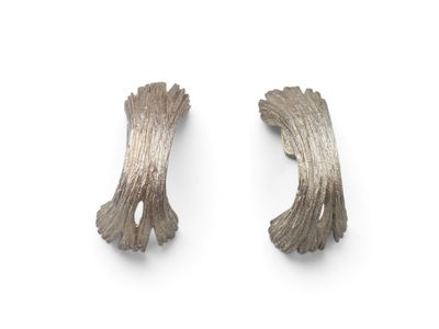 two pieces of silver metal on a white surface