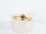 a close up of a gold ring with a sapphire stone