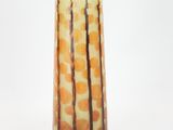 orange and green glass vase with trees on it against a white background