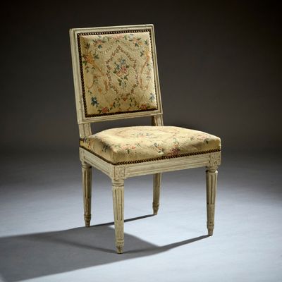 un fauteuil rembourré dont l'assise et le dossier sont recouverts d'un tissu à motifs floraux