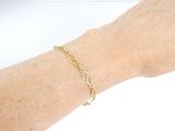 someone is wearing a bracelet with a gold chain on their arm
