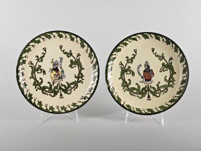 une paire d'assiettes vertes et blanches ornées d'oiseaux et de vrilles