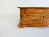 une petite boîte en bois sur laquelle repose une clé