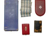 une petite collection d'objets comprenant un livre, un portefeuille et une médaille