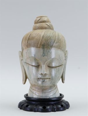 un gros plan sur la statue d'une personne portant un chignon sur la tête