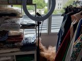 une photo d'une pièce où se trouvent beaucoup de vêtements et une lampe annulaire