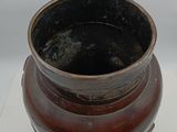a brown vase sitting on top of a white table