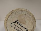 a small white plate with a black writing on it