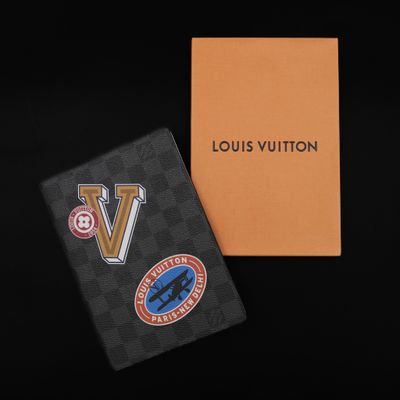 a louis vuitton passport case with a sticker on it