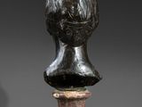 a bronze bust of a woman on a marble pedestal