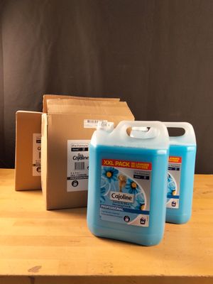 une bouteille de liquide posée sur une table à côté d'une boîte en carton