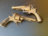 une paire de vieux revolvers posés sur une surface métallique