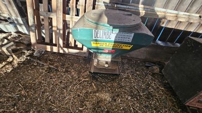 a machine that is sitting on the ground in front of a fence