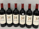 six bottles of red wine are lined up on a white surface