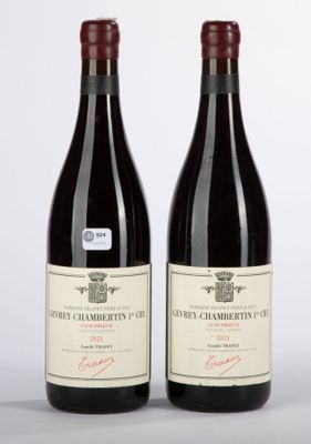 two bottles of red wine sitting next to each other on a table